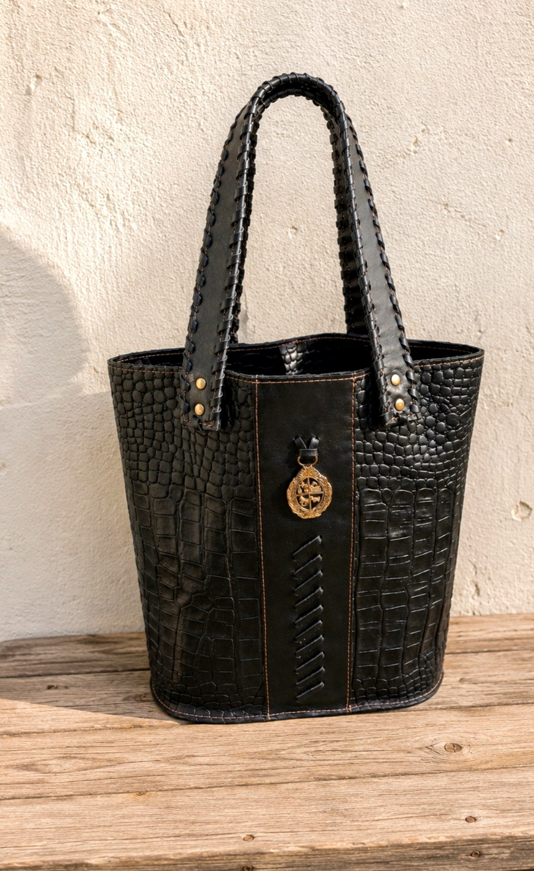 Bolso matero negro con cuero croco y liso, asas trenzadas y medallón dorado