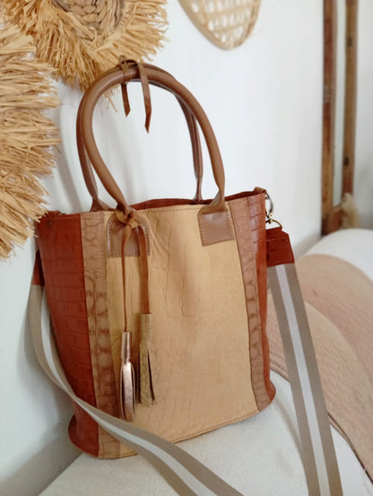 Bolso matero de cuero croco terracota y beige con lazo caramelo y correa rayada.